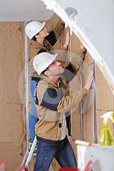 Plasterers covering the wall