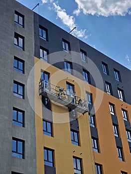 plasterers insulate the facade of an apartment building