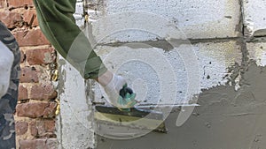 Plastering cement at wall for renovation house. Plasterer smoothing plaster on wall. Putty brick wall background