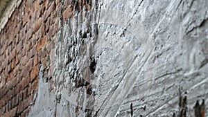 Plastering cement at wall for renovation house. Plasterer smoothing plaster on wall. Putty brick wall background