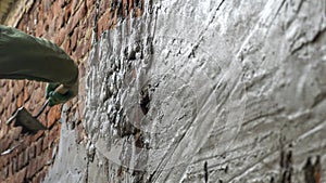 Plastering cement at wall for renovation house. Plasterer smoothing plaster on wall. Putty brick wall background