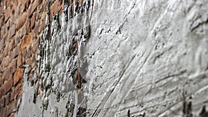 Plastering cement at wall for renovation house. Plasterer smoothing plaster on wall. Putty brick wall background