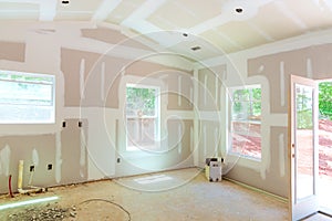 Plastering drywall new home industry on finishing putty in the room walls plasterboards with room under construction photo