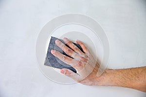 Plastering man hand sanding the plaster