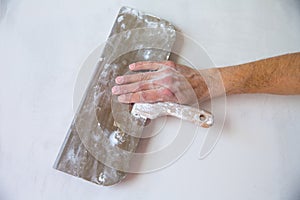 Plastering wall with plaste and plaster spatula trowel