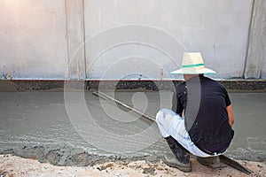 The tiler is working to smooth the cement surface.
