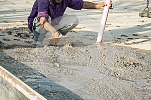 The tiler is working to smooth the cement surface.