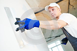 Plastering. Worker spackling a wall with putty