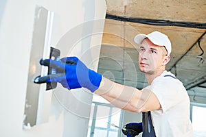 Plastering. Worker spackling a wall with putty