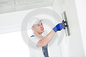 Plastering. Worker spackling a wall with putty