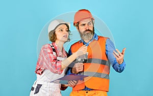 Plastering works. Couple look documents. Woman and man safety hard hat. Couple planning changes renovation apartment