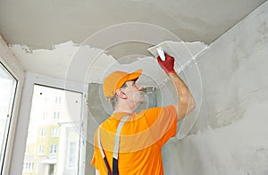 Plasterwork and painting preparation. craftsman applying plaster or filling on ceiling