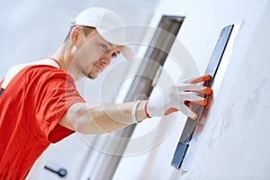 Plasterwork and wall painting preparation. craftsman applying plaster or filling