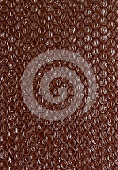 Plastic background texture cellophane wrapping packing wrap packet bead ball color maroon bordo brown chocolate