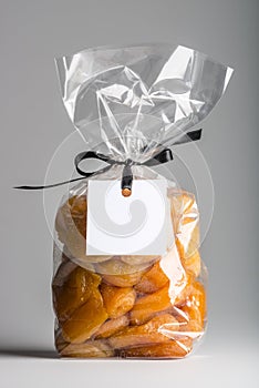 Plastic bag of dried apricots with ribbon and blank label