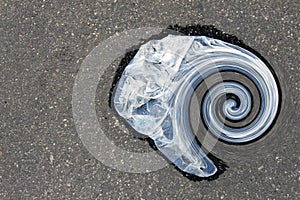 Plastic bag lying on the asphalt (spiral)