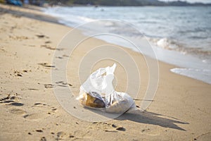 Plastic bag lying on a sandy tropical beach. environmental pollution