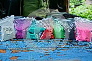 plastic bags of colored sand on a blue table