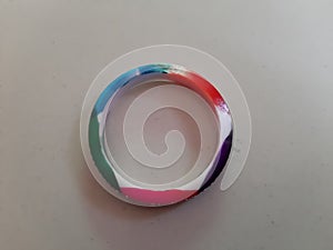 A plastic bangle with color.The colored plastic bangle is lying on the white lapis. photo