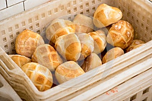Plastic basket with freshly baked bread rolls