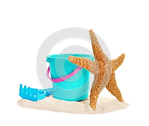 Plastic beach toys and sea star on pile of sand