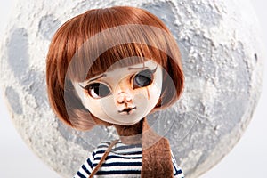 Plastic big eyes doll portrait with moon sky background