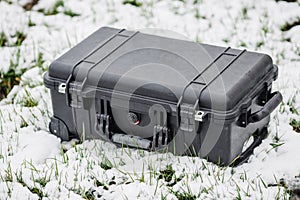 Plastic black protector case lying on the grass and snow