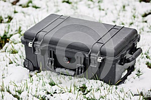 Plastic black protector case lying on the grass and snow