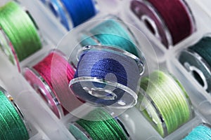 Plastic bobbins for a sewing machine with multi-colored threads