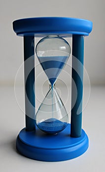 Plastic body of glass timeglass with blue sand pouring inside