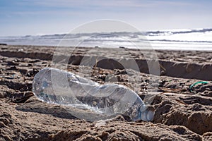 Plastic bottle on the beach, pollution photo