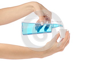 Plastic bottle with blue mouthwash liquid in hand