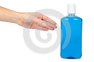 Plastic bottle with blue mouthwash liquid in hand, isolated on white background