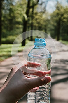 Plastic bottle of clean drinking water in hand, source of life