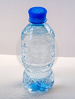 Plastic bottle with clean water on a light background.