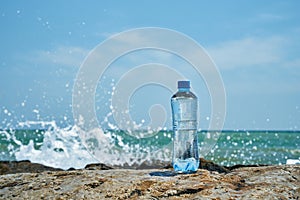 El plastico una botella. Costa de el mar. ondas piedras 