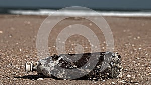 Plastic bottle covered in sea barnacles and cast ashore
