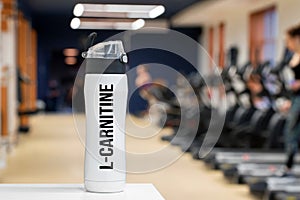 Plastic bottle or cup with L-carnitine fitness drink close up
