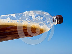 Plastic bottle of drink and blue sky background, global environment conservation concept