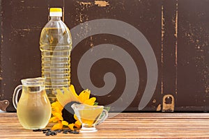 Plastic bottle and glass jars with sunflower oil on wooden table
