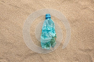 Plastic bottle lies on the beach and pollutes the sea. Spilled garbage on the beach