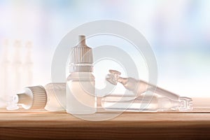 Plastic bottle and pipettes with eye medication on table room