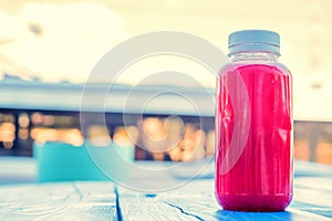 Plastic bottle with red fruit drink in restaurant