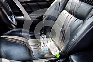 Plastic bottle of water placed on car seat and exposed to sun in sunny day,bottle of drinking water in car,sunlight,very hot,