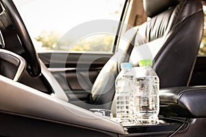 Plastic bottle of water placed on car seat and exposed to sun in sunny day,bottle of drinking water in car,sunlight,very hot,