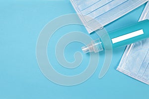 Plastic bottle with a white label and medical masks on a blue background.