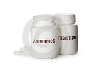 Plastic bottles with antibiotic pills on white background
