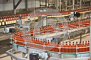 Plastic bottles for beer or carbonated beverage moving on conveyor