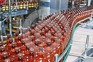 Plastic bottles with beer or carbonated beverage moving on conveyor