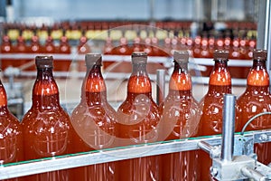 Plastic bottles with beer or carbonated beverage moving on conveyor